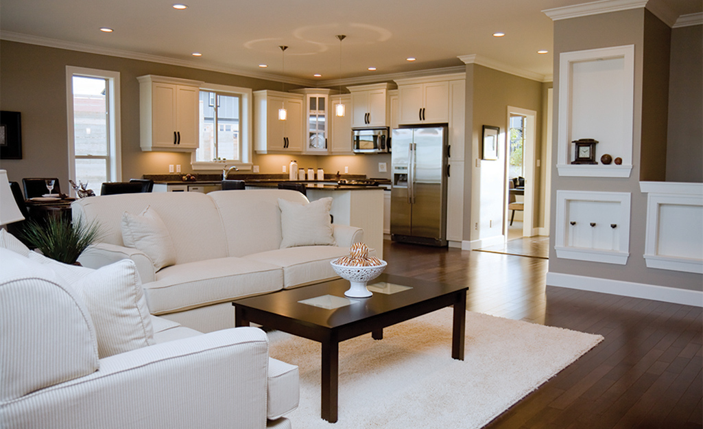 Recessed lights provide lighting for an open floor plan living room, kitchen and dining area. 
