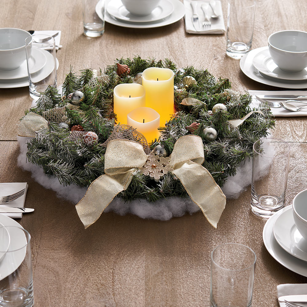 A DIY Christmas centerpiece placed in the middle of a table.