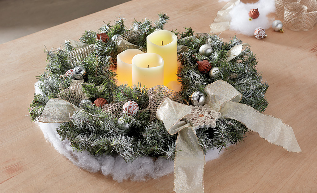 A complete DIY holiday wreath covered in snow and ornaments.