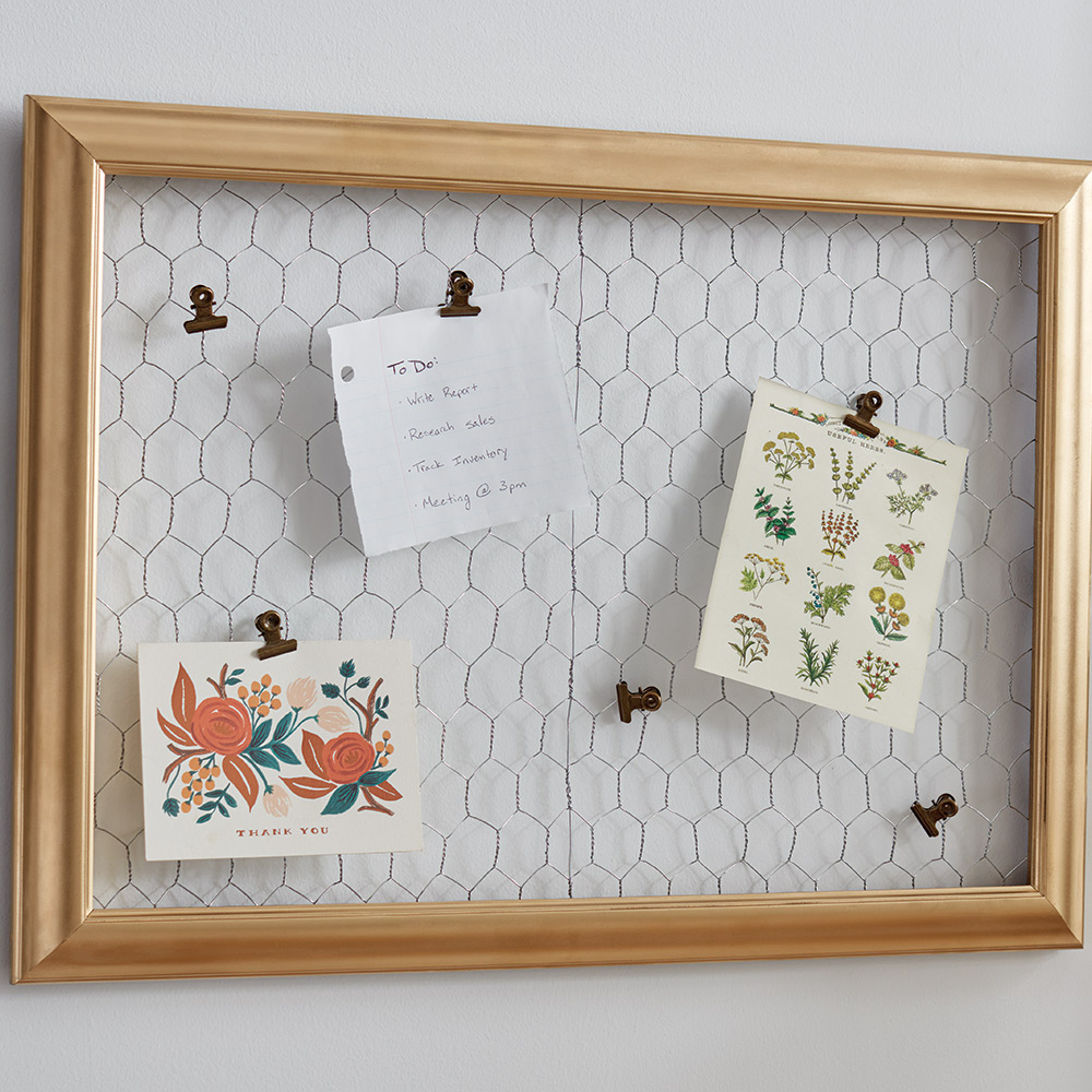 Notes clipped to a chicken wire memo board