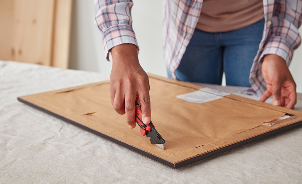 Person removes backing from frame