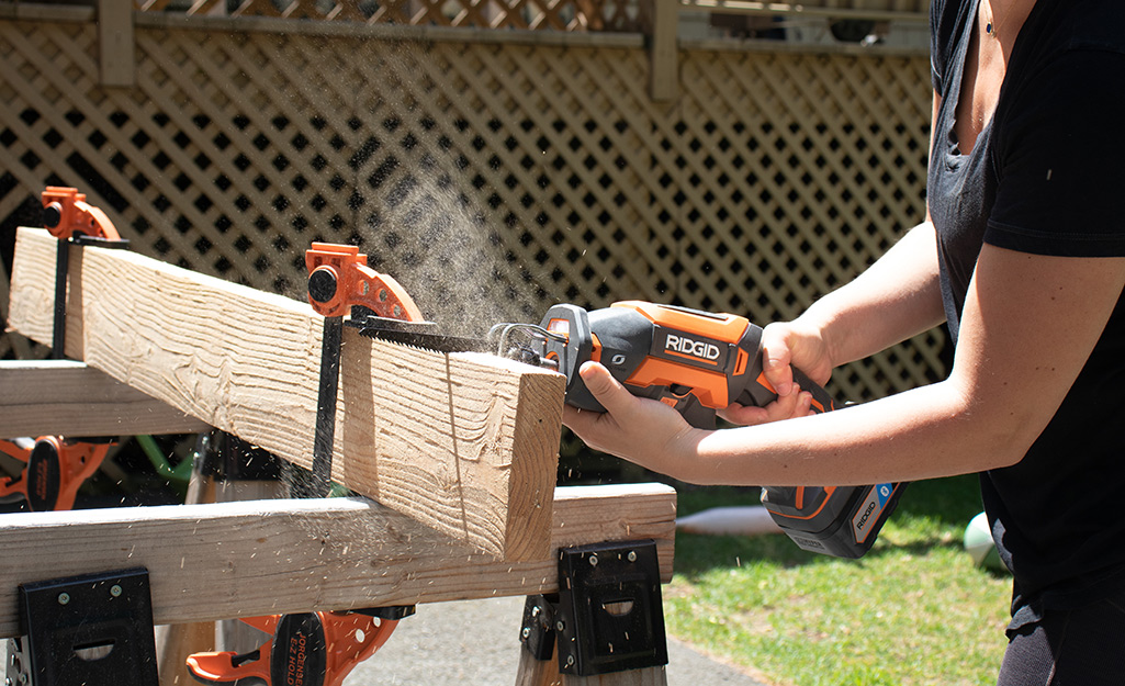 A person cuts a length of wood for a cutting board project.