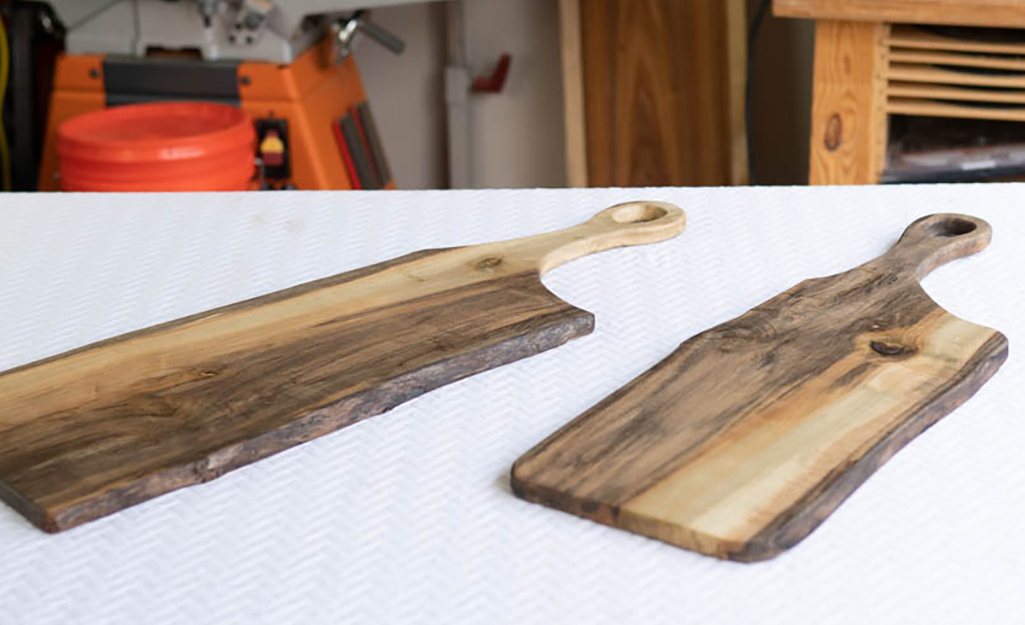 Two hardwood cutting boards with carved handles.