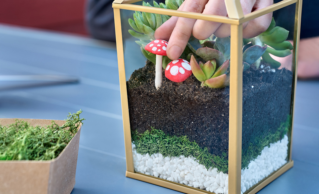 A fairy garden being created inside a terrarium.