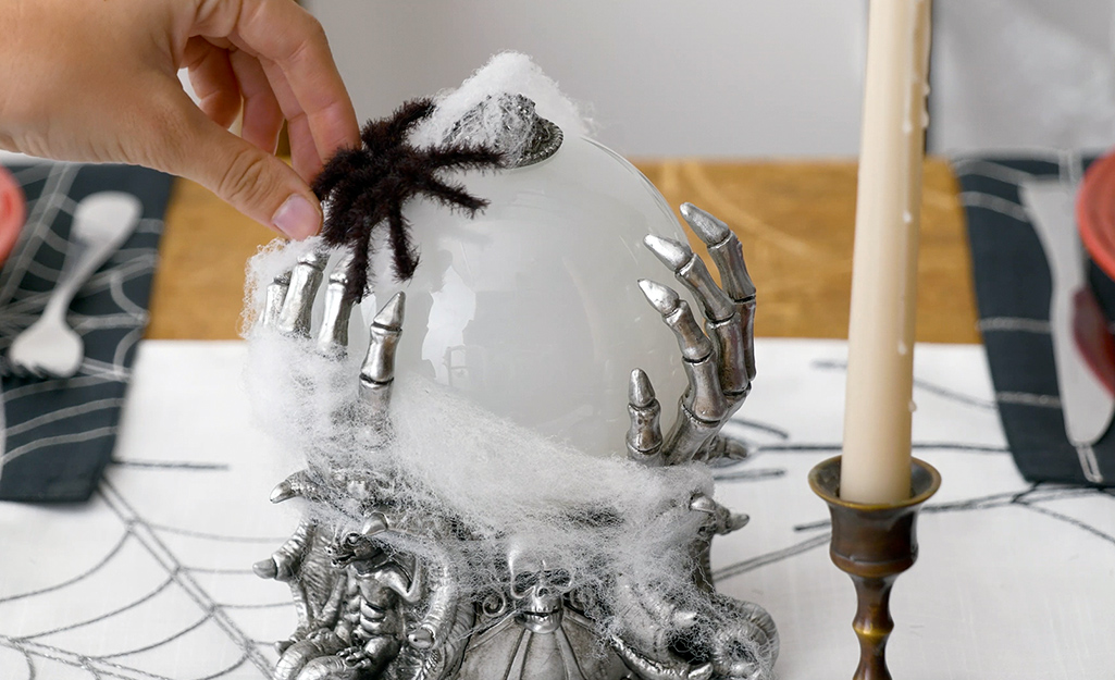 A crystal ball is decorated with spiderwebs and fake spiders. A crystal ball is decorated with spiderwebs and fake spiders.