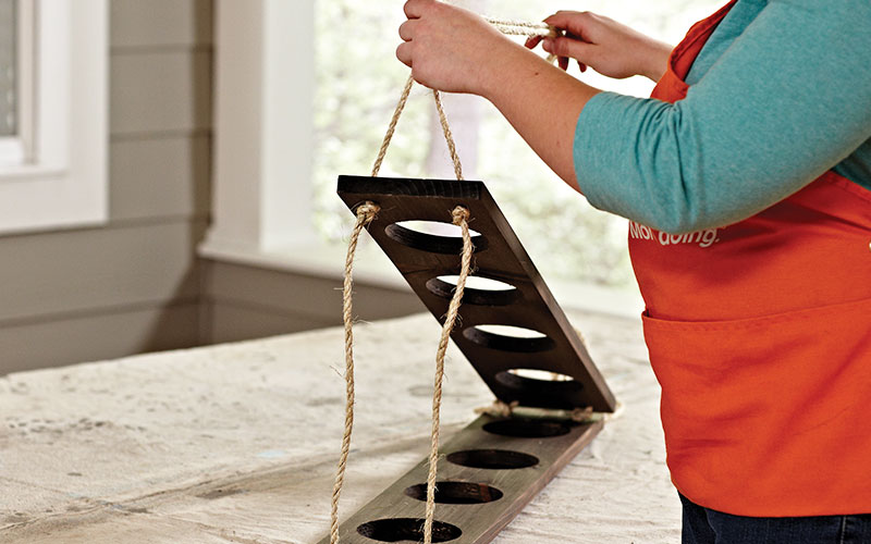 A person running ropes through the boards.