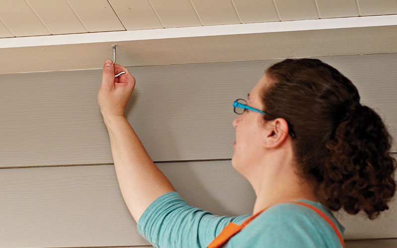 A person locating a spot to hang herb garden.