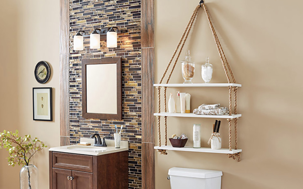 A DIY hanging rope shelf on the wall of a bathroom.