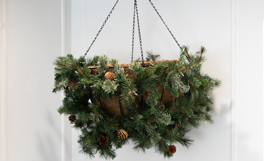 A planter wrapped in garland hangs in the corner of the room.
