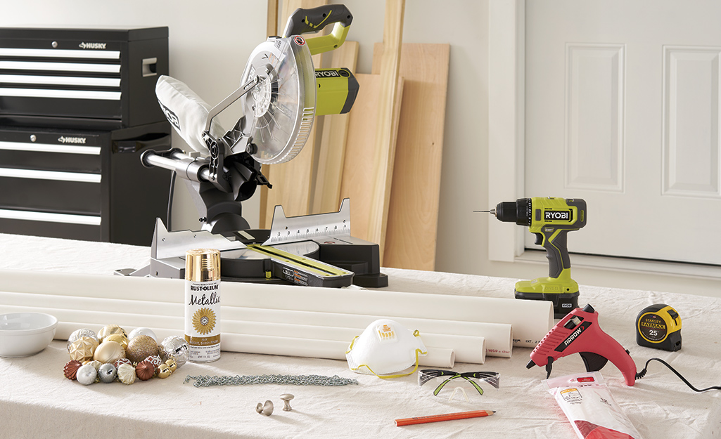 A circular saw, drill, PVC pipe and other materials gathered in a workshop.