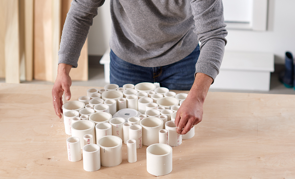 Someone arranging the cut PVC pipe into a circle.