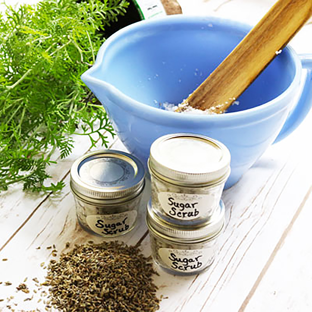 Lavender buds, jars and a bowl on a white table.