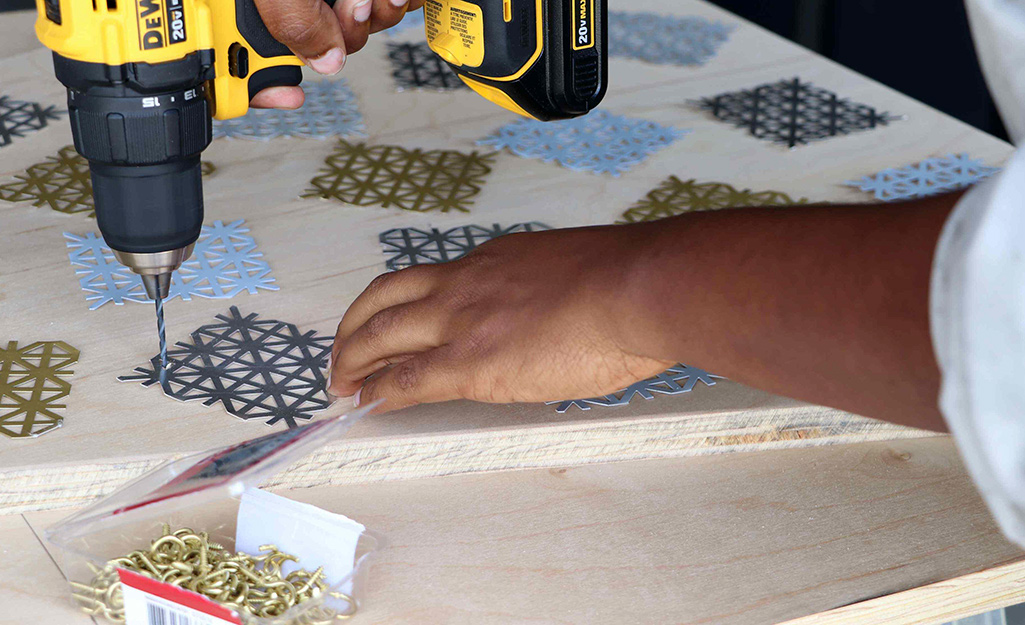 A drill is used to make holes for snowflakes.