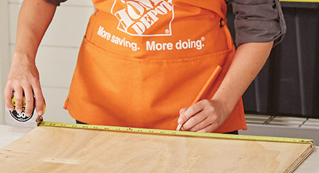 A person measuring a section of wood. A person measuring a section of wood.