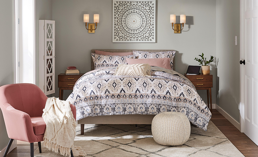 A bed with patterned sheets and seafood colored walls.