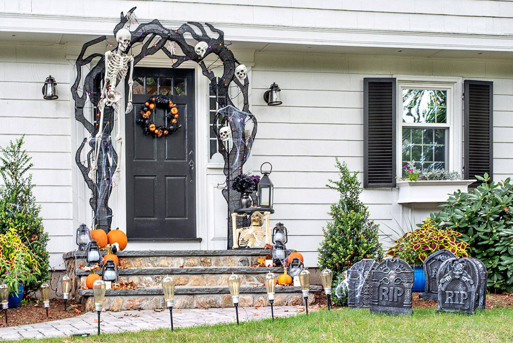 A front door and yard with Halloween decorations