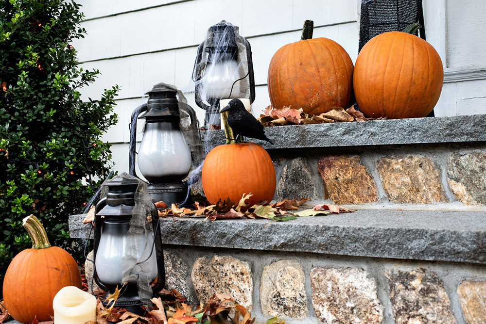 A close shot of lanterns and pumpkins on front steps