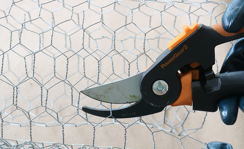 Person cutting chicken wire.