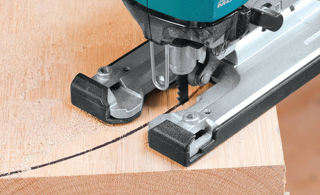 A saw being used to cut rounded ends on a board to make a tree swing. A saw being used to cut rounded ends on a board to make a tree swing.