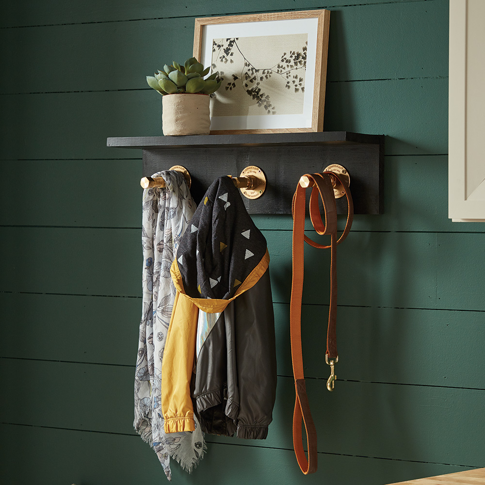 A DIY coat hanger made with wood and pipe.