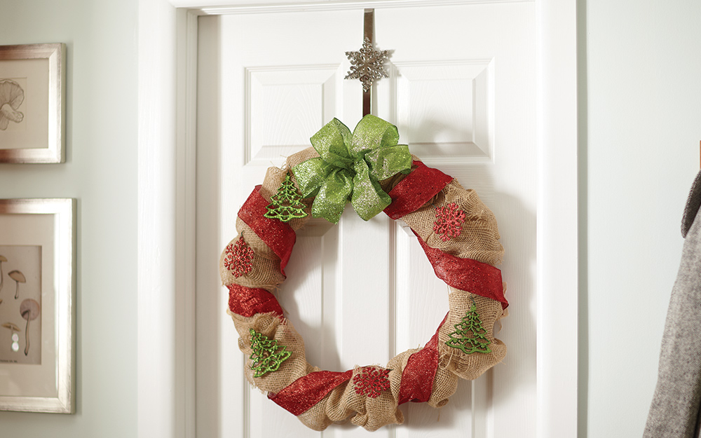 Burlap wreath with ribbons hanging on a door.