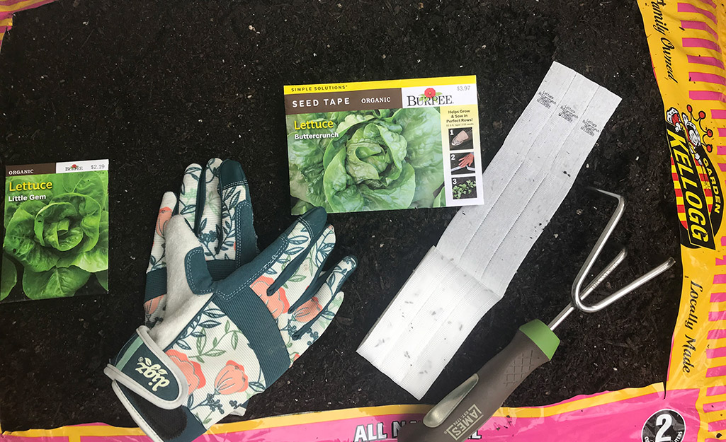 Seeds, gardening gloves and a hand cultivator in a bag of garden soil. Seeds, gardening gloves and a hand cultivator in a bag of garden soil.