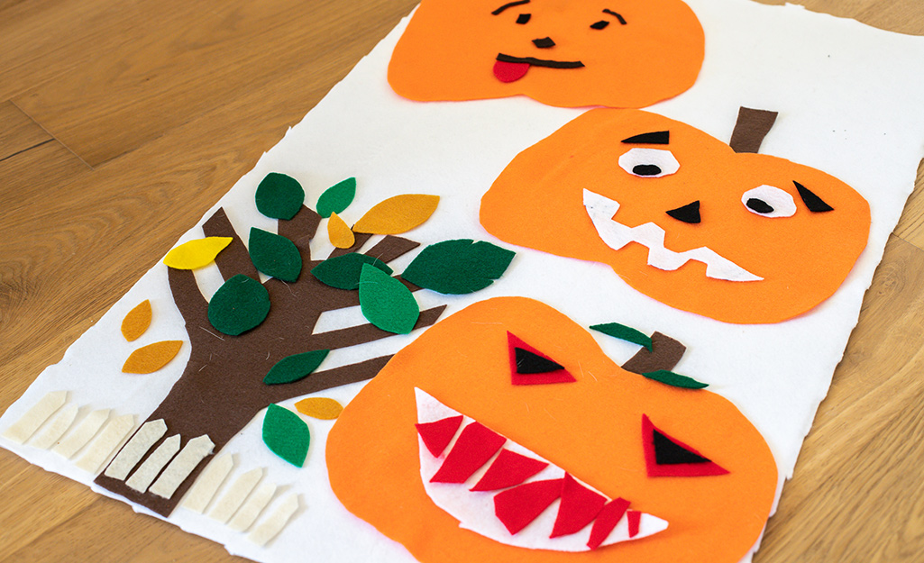 Felt pumpkin artwork lying on a table.