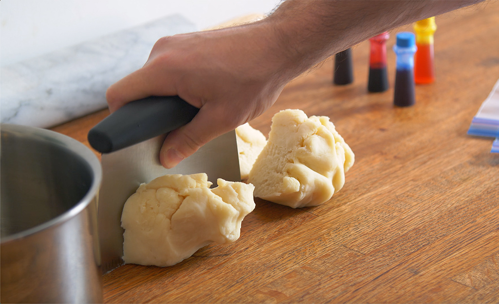 A person cuts dough into sections.