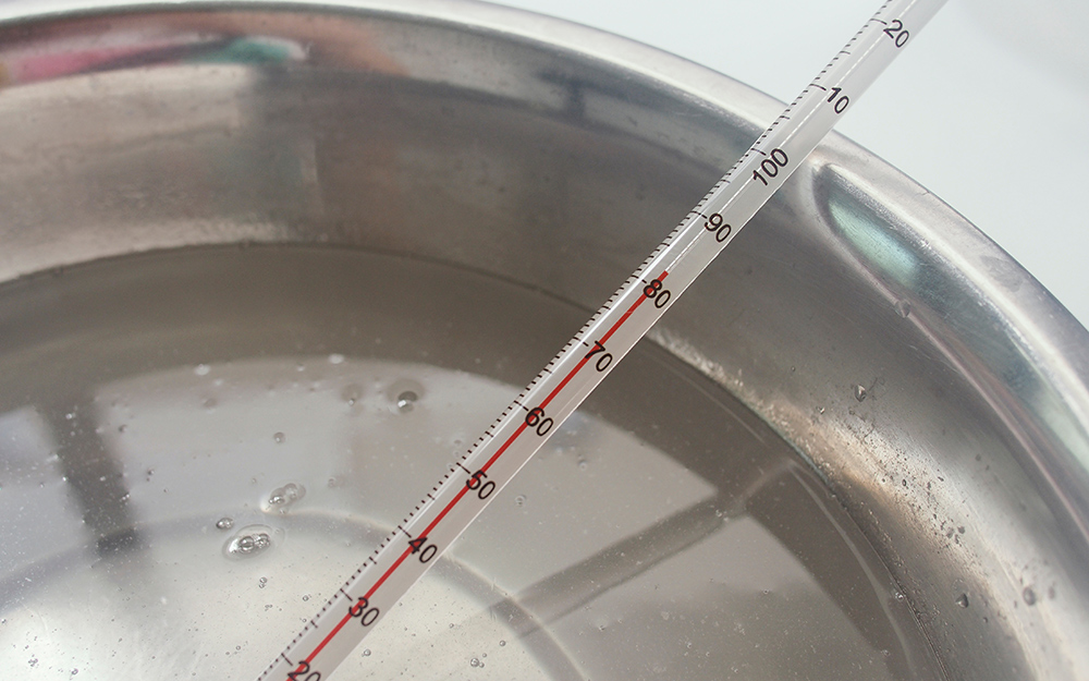 A bowl of water with a thermometer in it. A bowl of water with a thermometer in it.