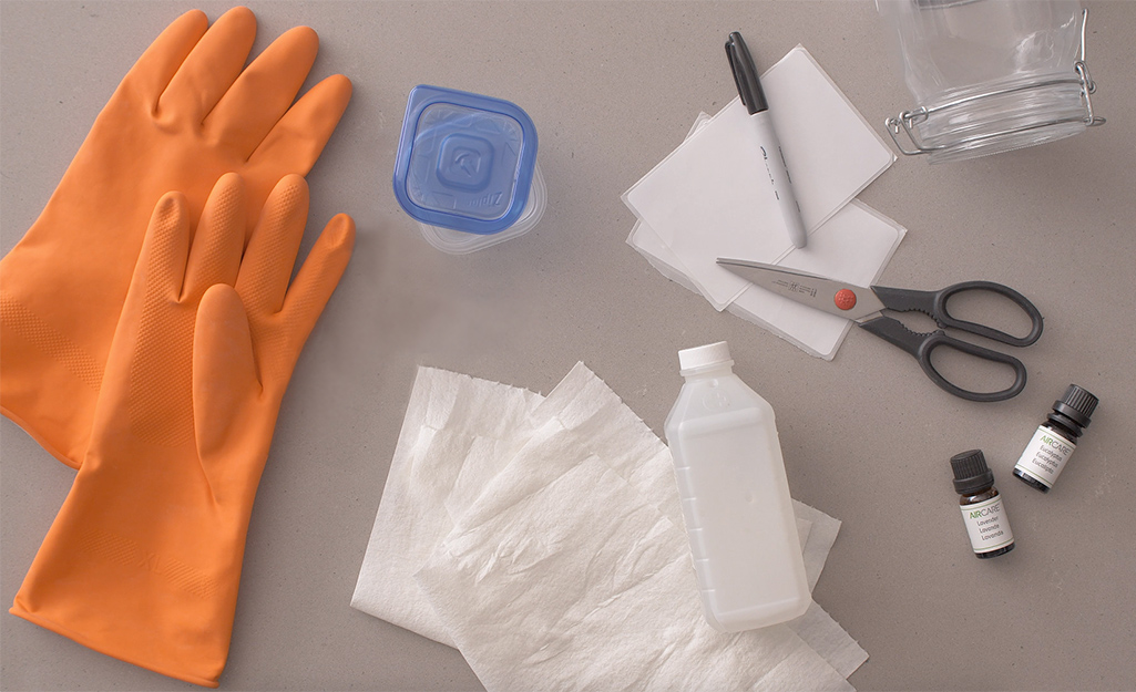 Rubber gloves, rags, alcohol and other supplies on a counter. 