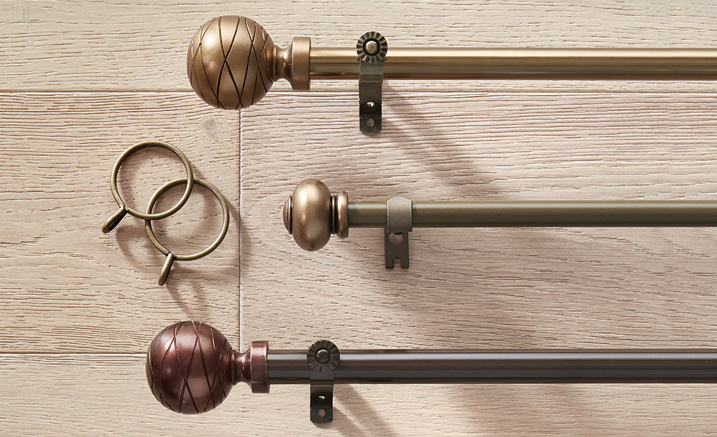 Different decorative curtain rods and hooks lying on a table.