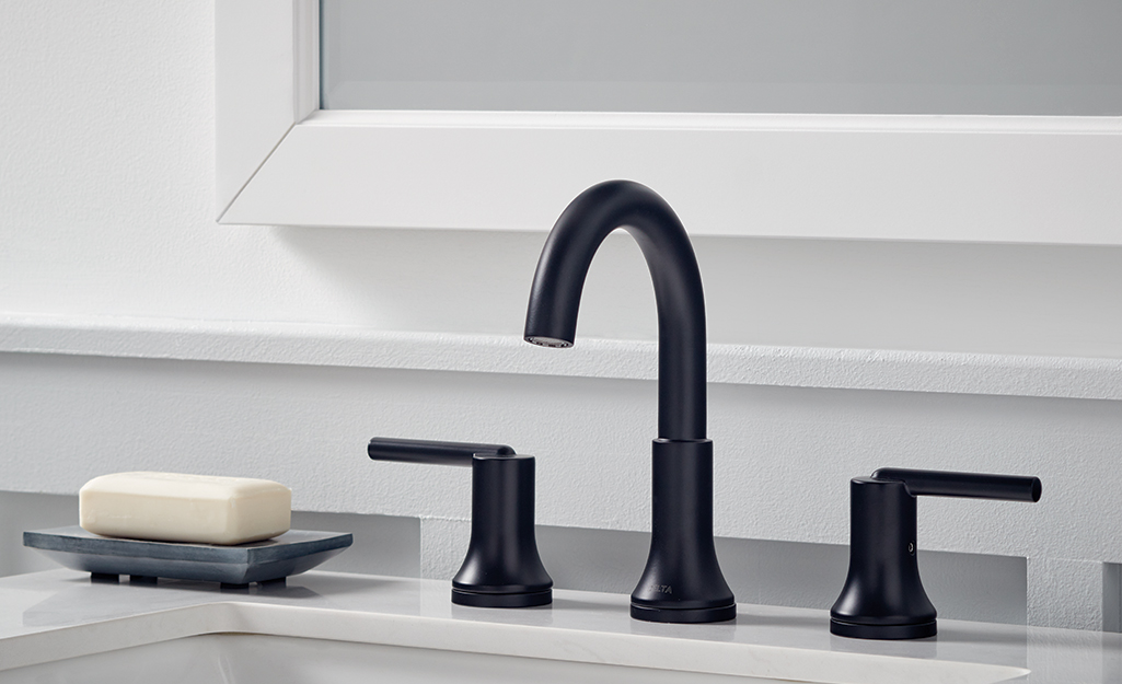A widespread bathroom faucet is mounted to a bathroom sink.