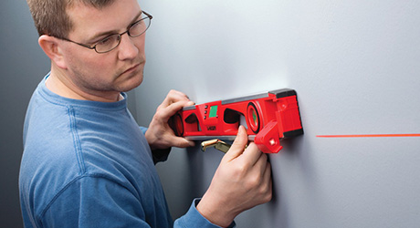 Man takes measurement with laser distance measure