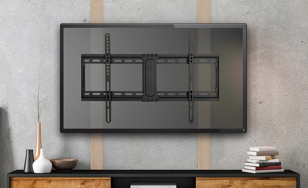 A picture of a TV wall mount on a wall above a credenza.
