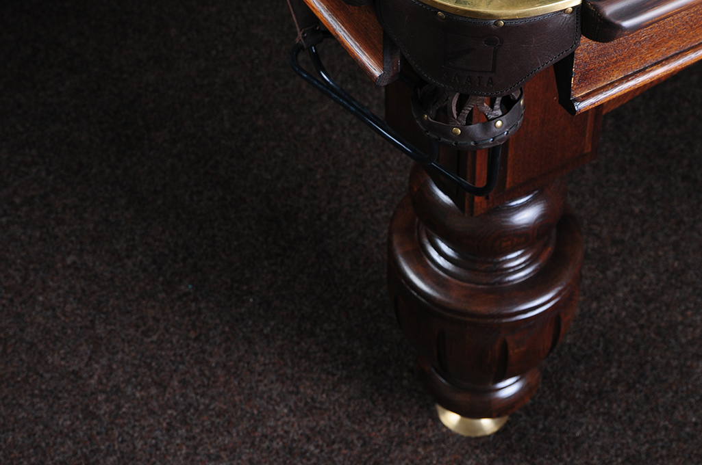 Wood pool table leg resting on the floor.