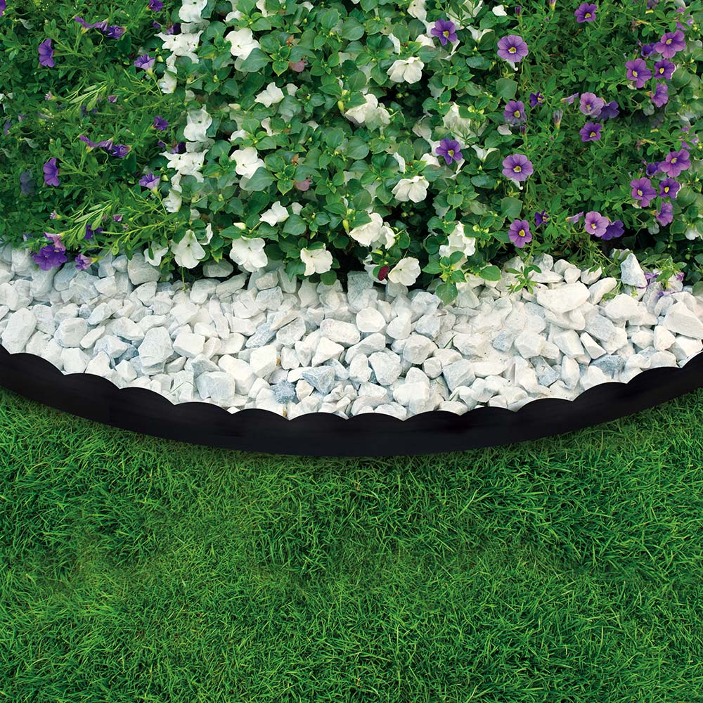 Decorative edging stands out against white rocks in a landscaping bed.