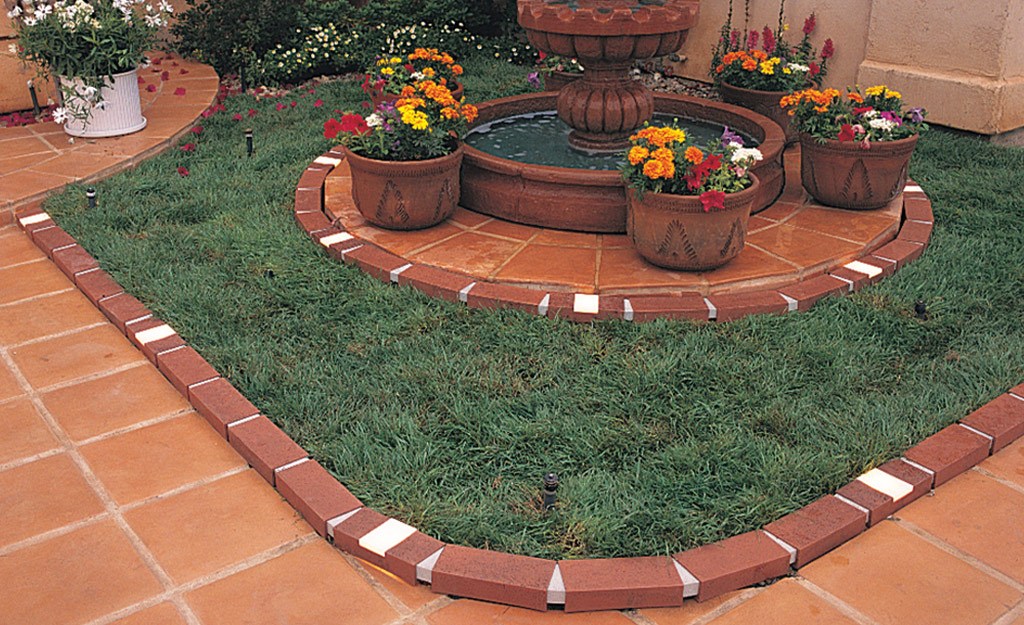 Red brick edging defines a walkway and landscape bed.