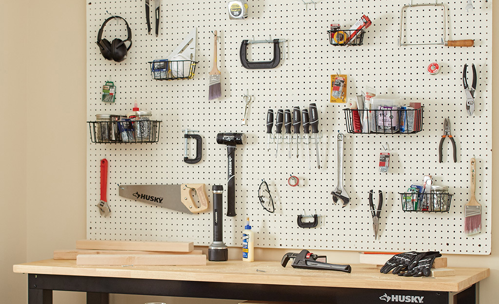 A pegboard with organized tools above a worktable.