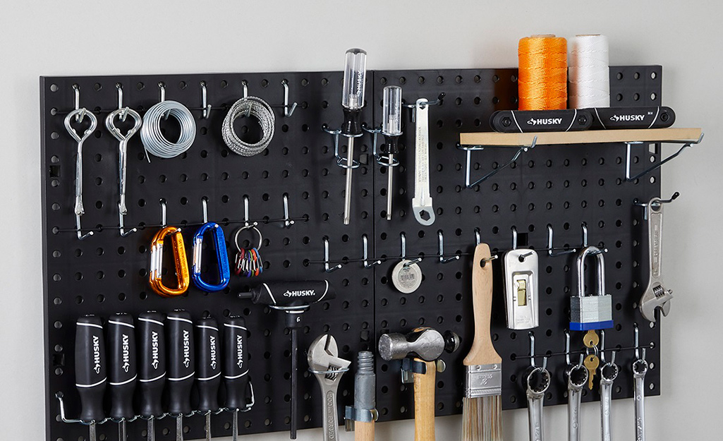 A black pegboard with assorted tools.
