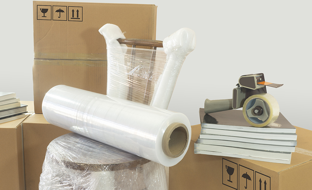 Moving supplies, including boxes, stretch wrap and packing tape, are gathered together.