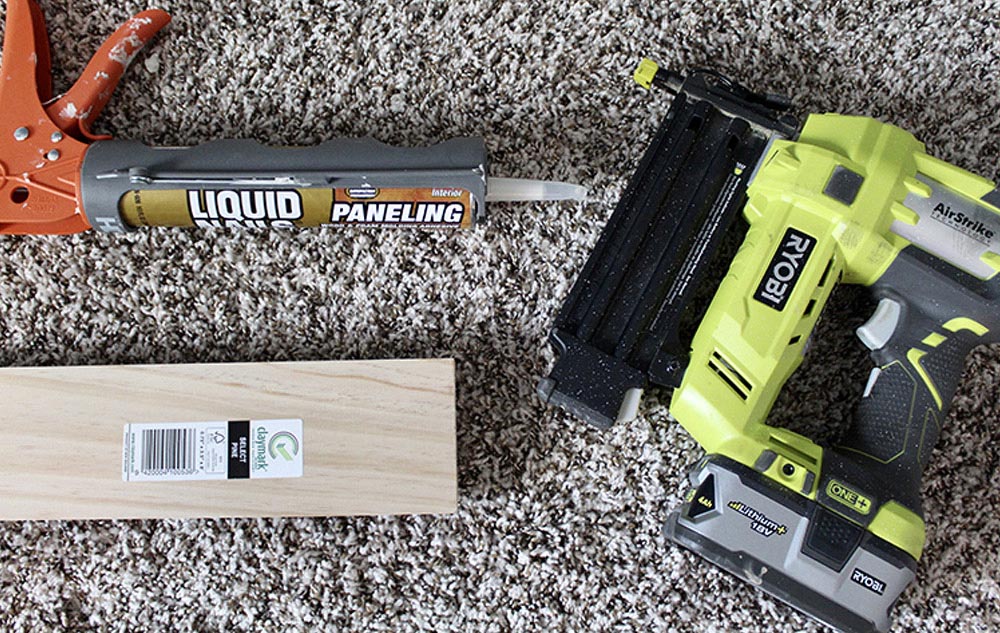 Various tools and materials needed to add paneling to a wall.
