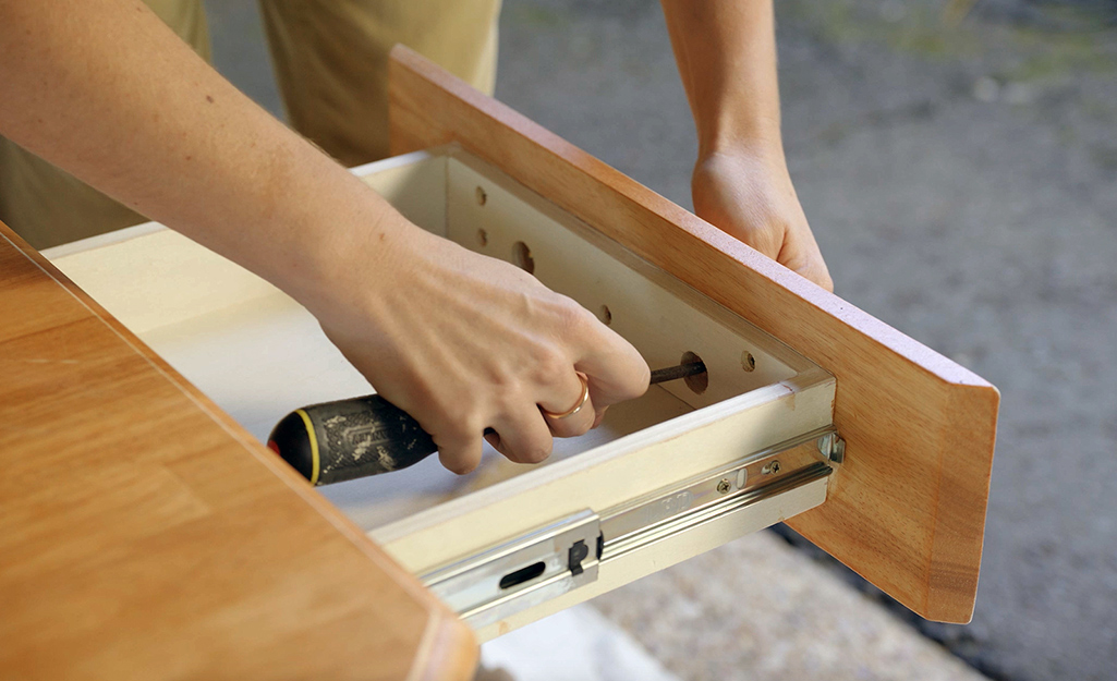 Someone removing a drawer front.