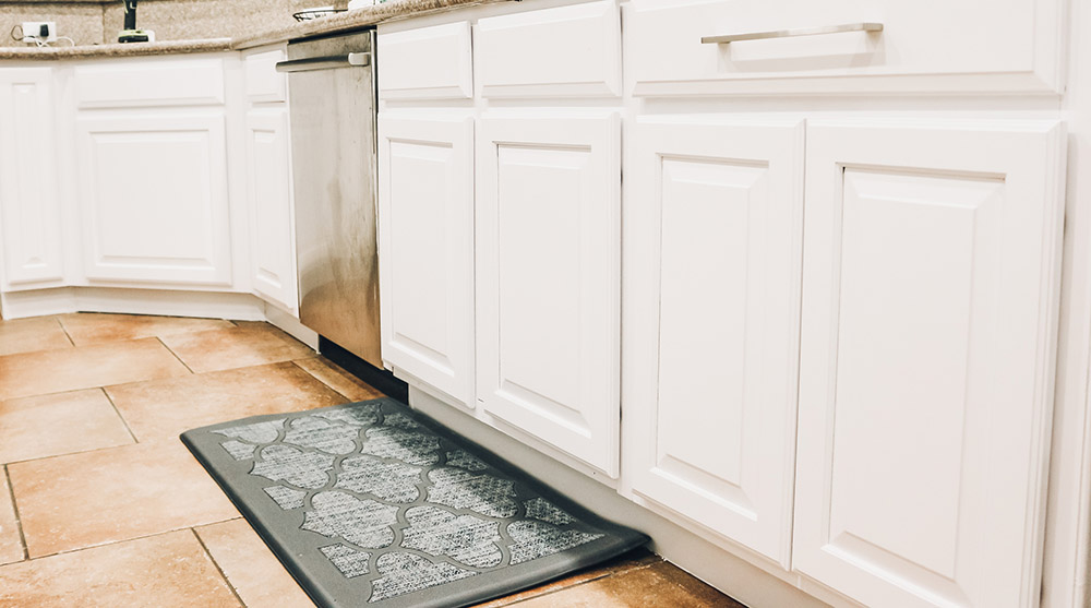 A shot of the bottom cabinets and a kitchen rug on the floor