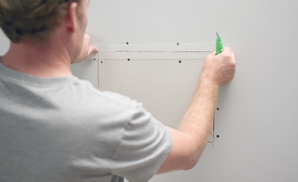 A person repairs a drywall seam.