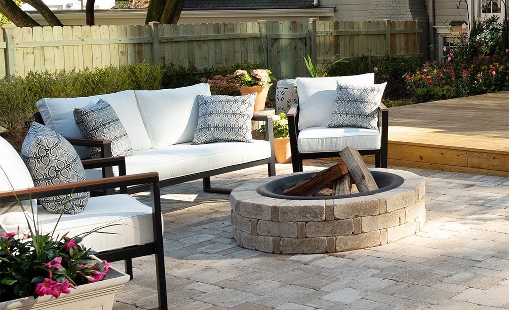 A wood-burning stone fire pit and seating on a patio.