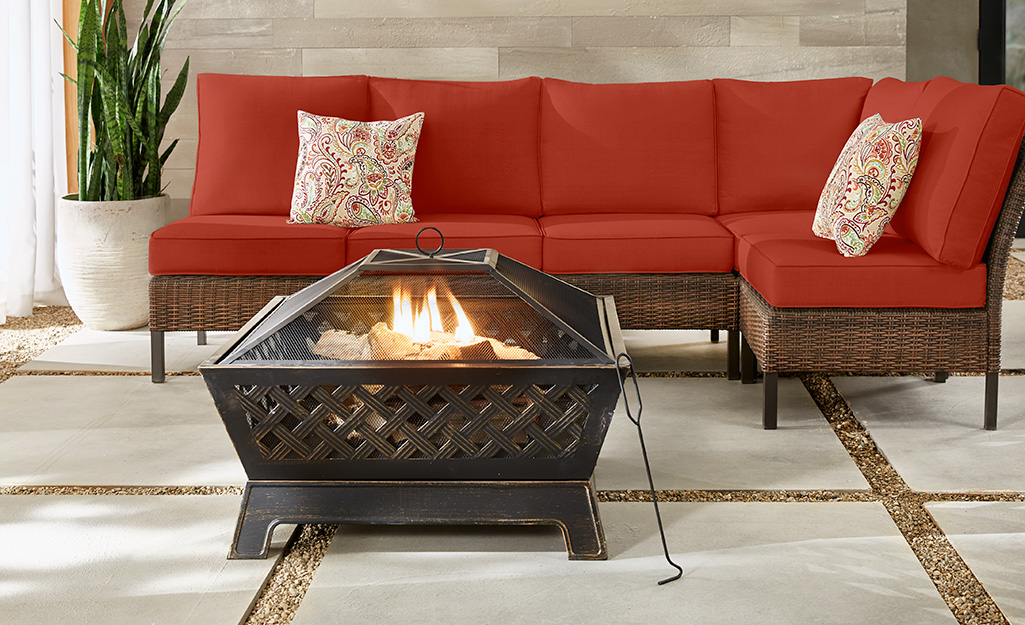 A metal fire pit and outdoor furniture on a patio.