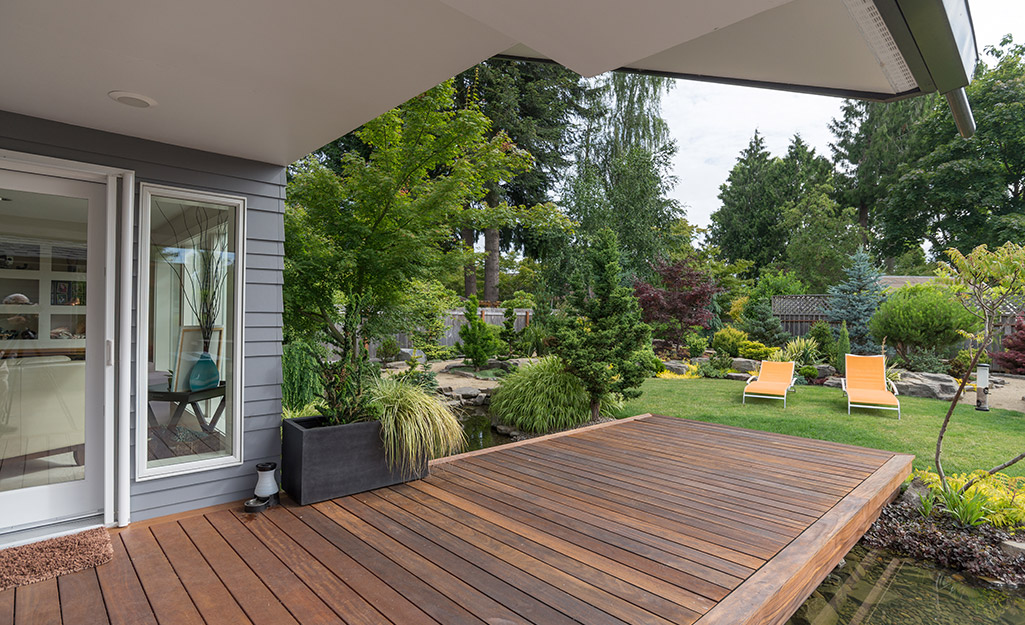 A simple wood deck that leads from the home into a seating area in the yard.