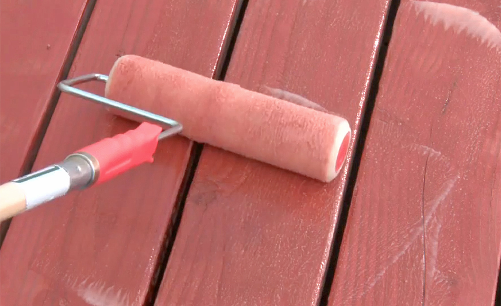 A person rolling cleaner on to a deck.