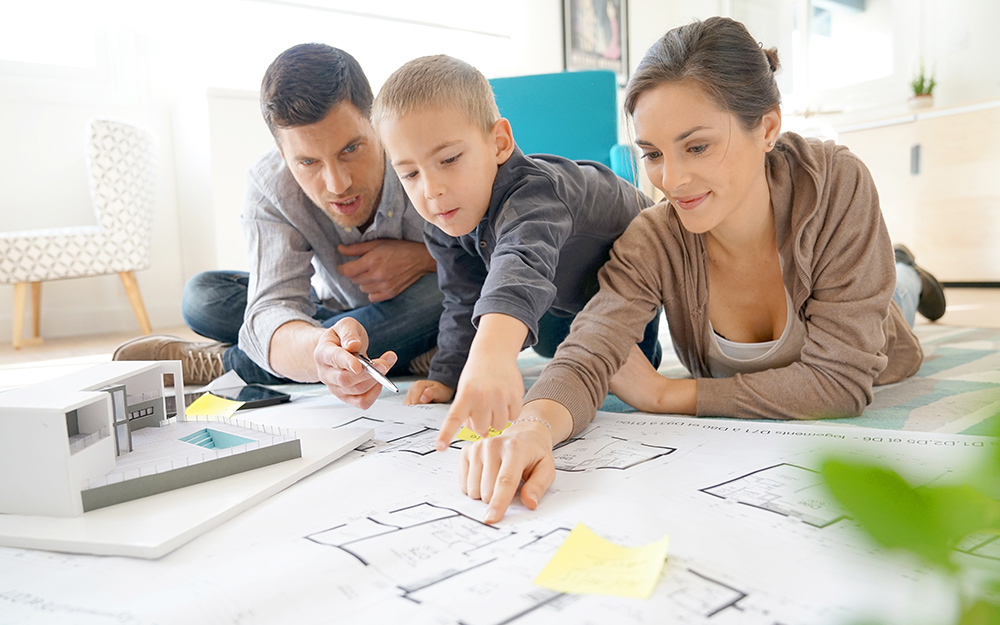 A family looks at a house diagram to make a fire emergency plan.