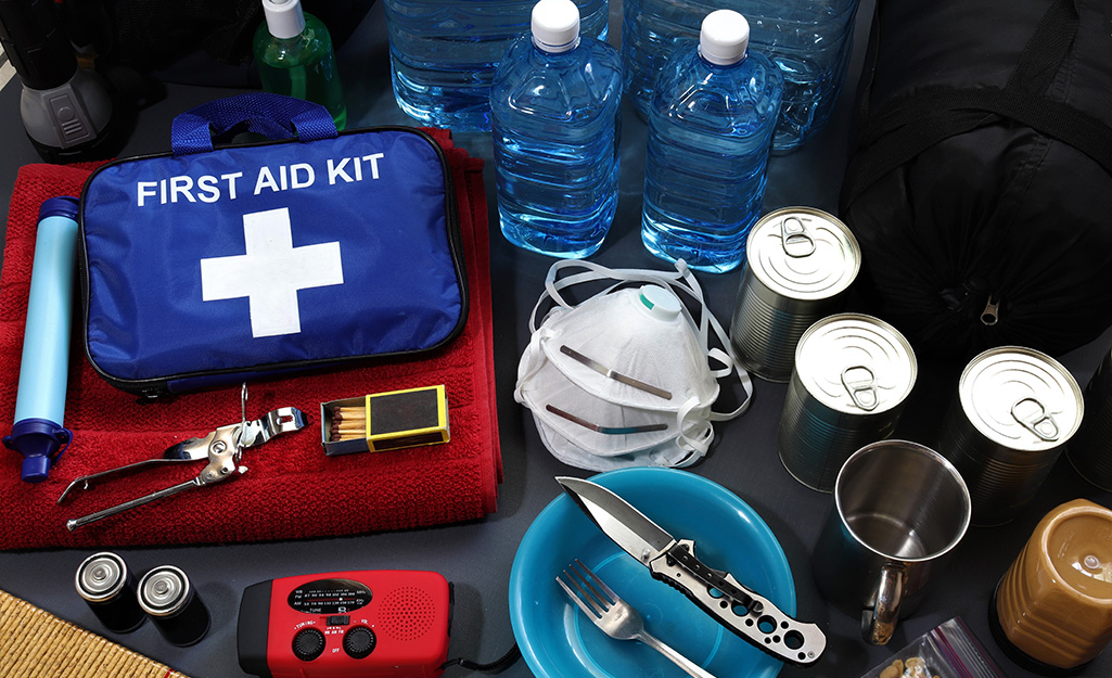 First aid kit, water and other emergency supplies sitting on a table.